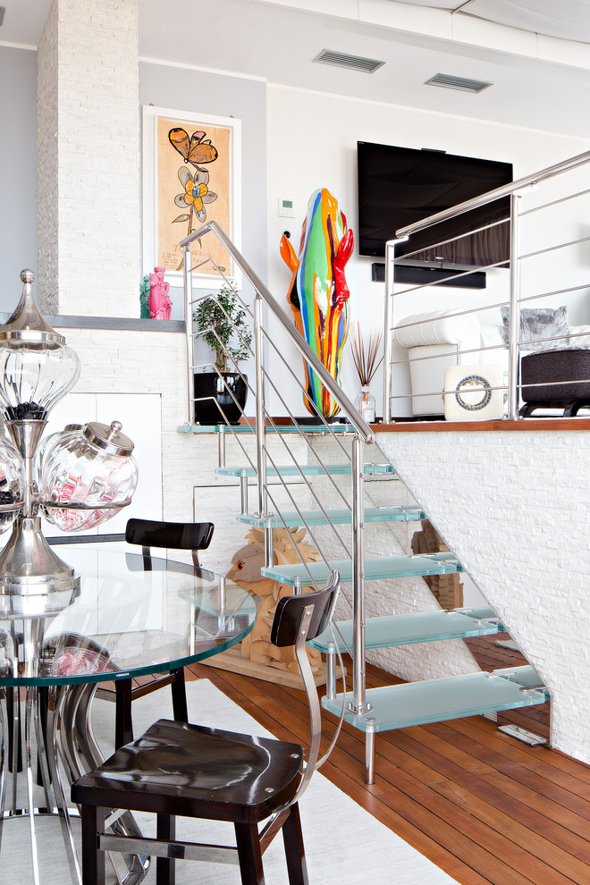 Inspiration for a small eclectic glass straight staircase in Bologna with open risers and metal railing.