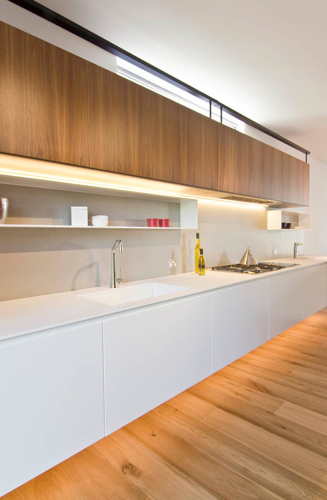 Large scandinavian l-shaped open plan kitchen in Sydney with quartz benchtops.
