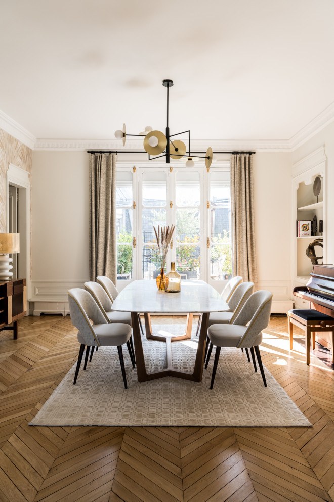 Immagine di una sala da pranzo minimal con pareti beige, pavimento in legno massello medio, pavimento marrone e carta da parati