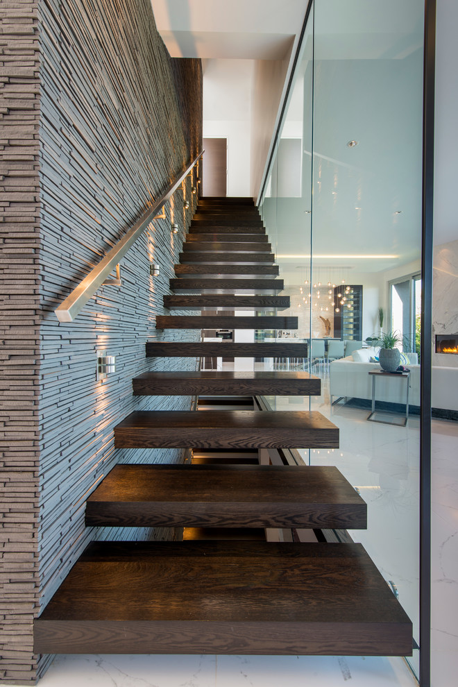 Design ideas for a contemporary wood straight staircase in Vancouver with open risers and metal railing.