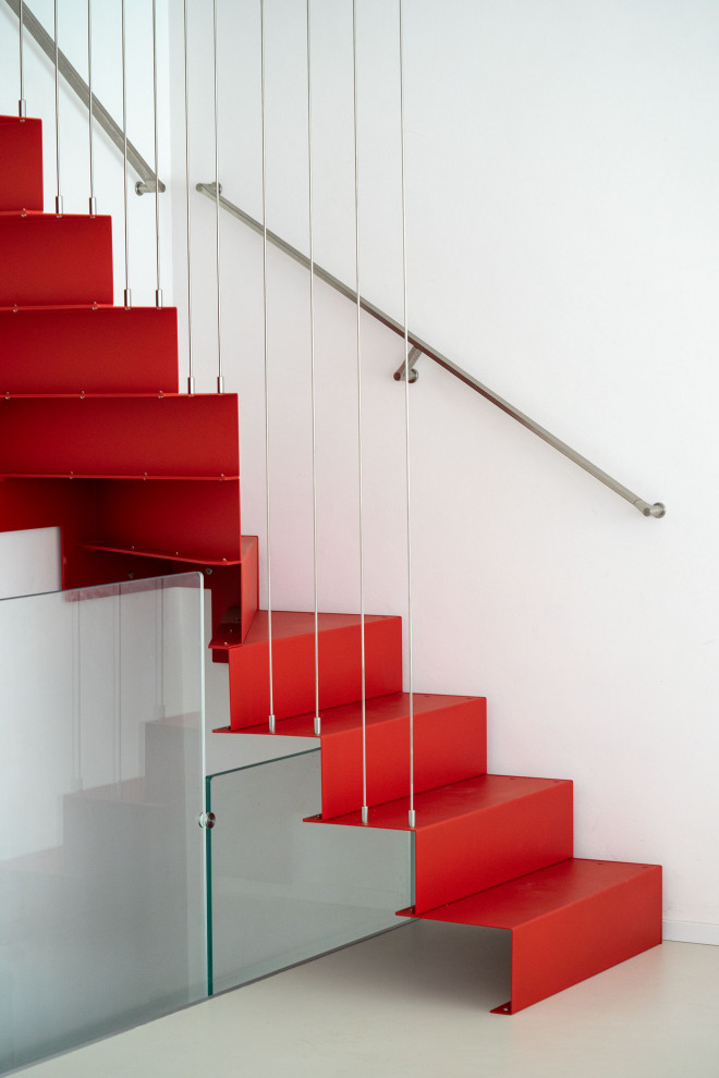 На фото: угловая металлическая лестница среднего размера в стиле модернизм с металлическими ступенями и перилами из тросов с