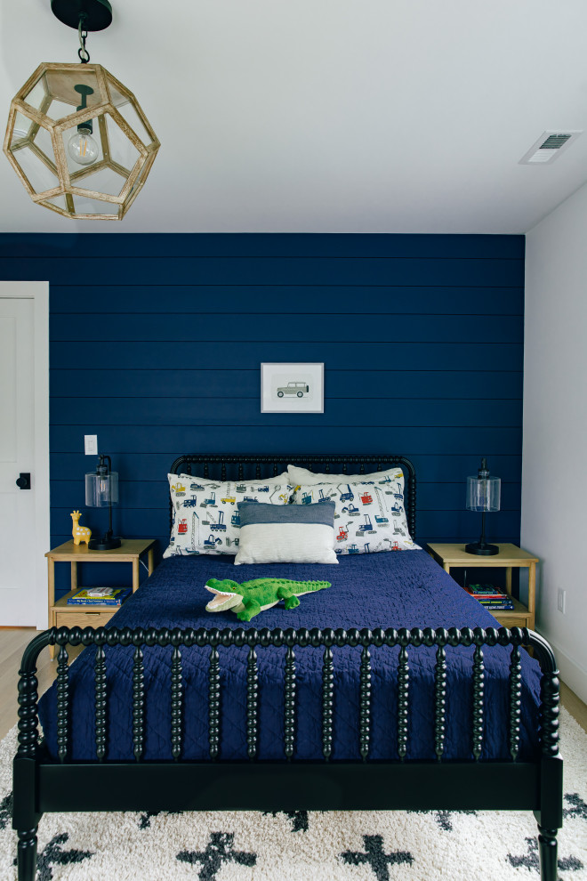 This is an example of a large beach style guest bedroom in Other with blue walls, light hardwood floors, no fireplace, brown floor and planked wall panelling.