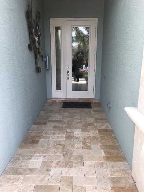 Large transitional travertine floor front door photo in Miami with blue walls and a glass front door