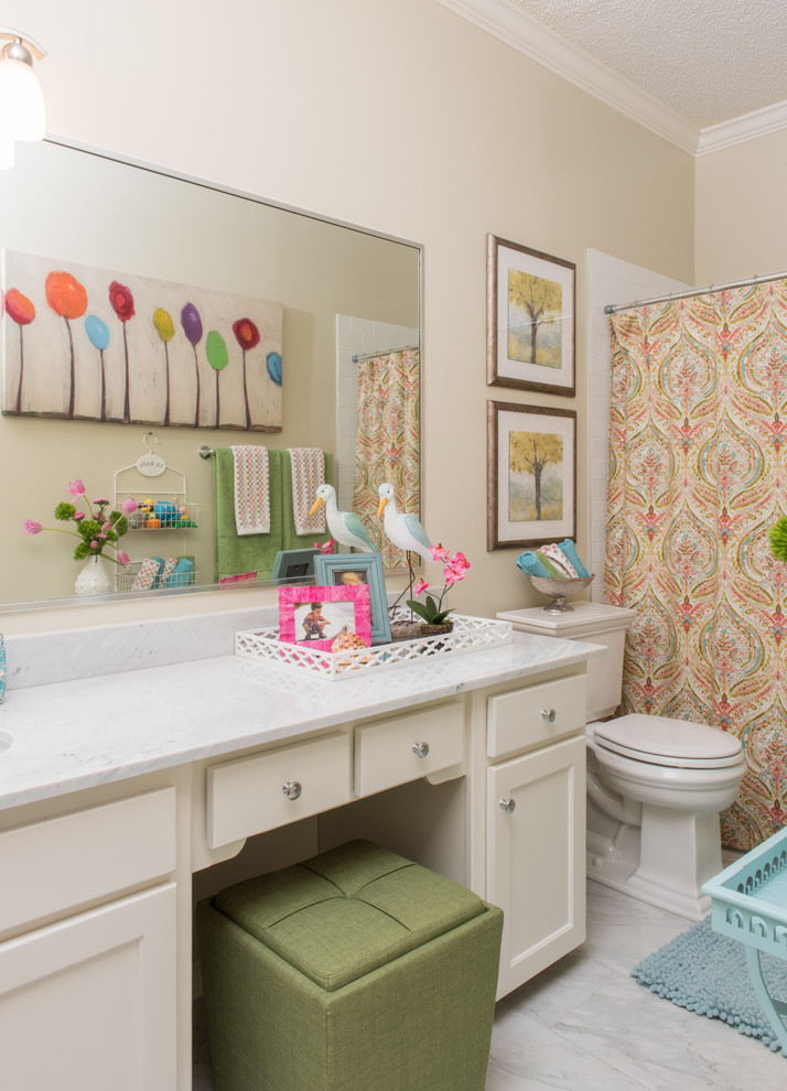 This is an example of a mid-sized traditional kids bathroom in Dallas with an undermount sink, shaker cabinets, white cabinets, marble benchtops, an alcove tub, a shower/bathtub combo, white tile, porcelain tile, beige walls and porcelain floors.