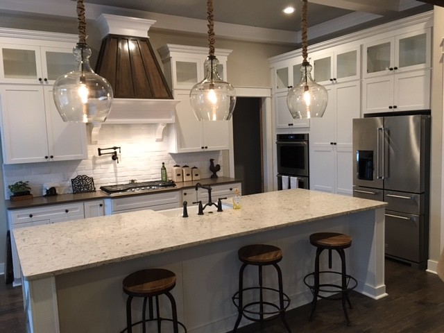 Kitchen - large transitional l-shaped dark wood floor kitchen idea in Columbus with a farmhouse sink, shaker cabinets, white cabinets, quartzite countertops, white backsplash, brick backsplash, stainless steel appliances and an island