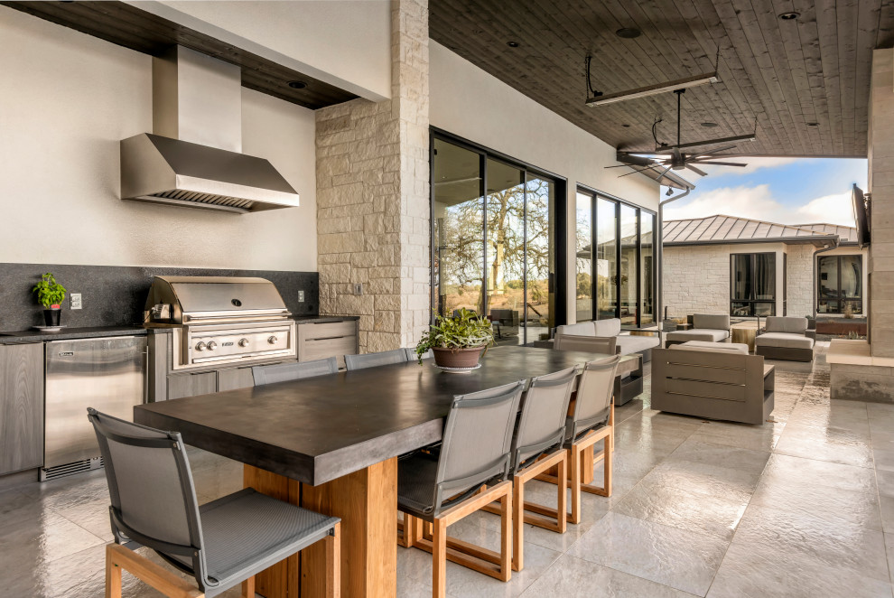 Design ideas for a contemporary patio in Austin with an outdoor kitchen, tile and a roof extension.