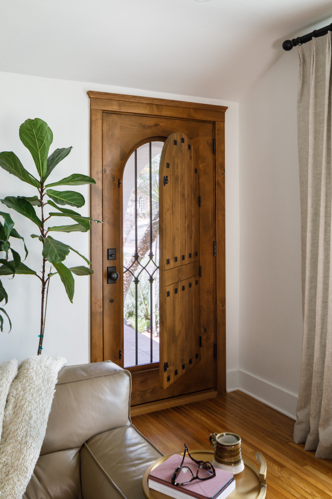Foto di una porta d'ingresso mediterranea di medie dimensioni con pareti bianche, pavimento in legno massello medio, una porta singola, una porta in legno bruno e pavimento marrone