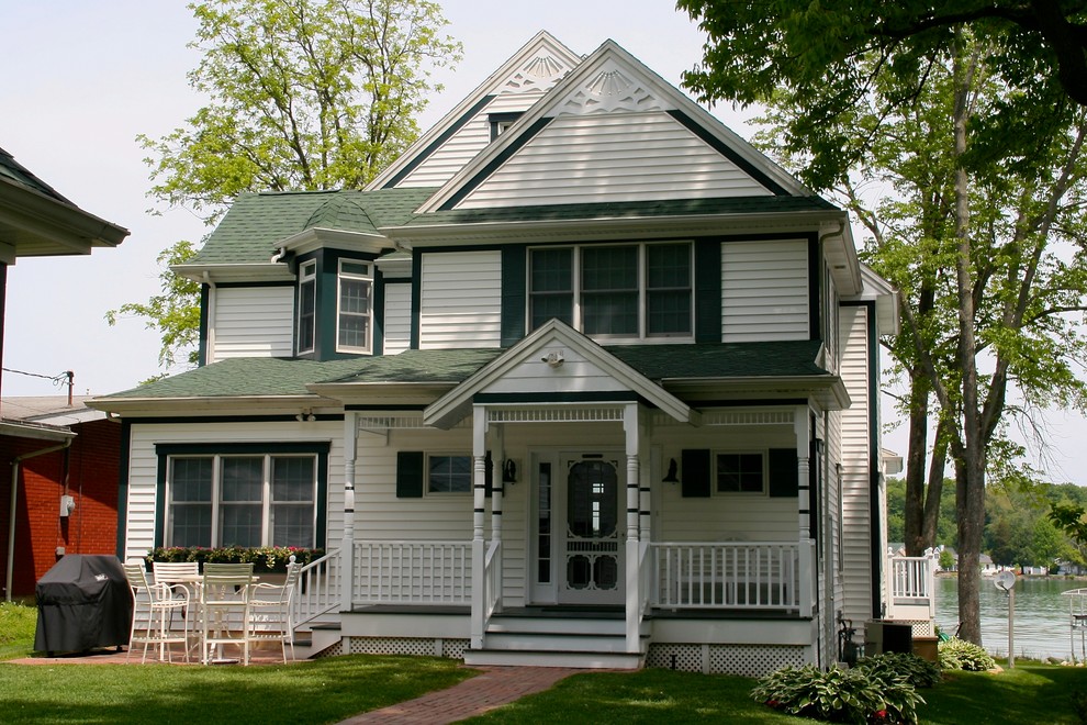 Design ideas for a mid-sized traditional three-storey white exterior in Other with vinyl siding.