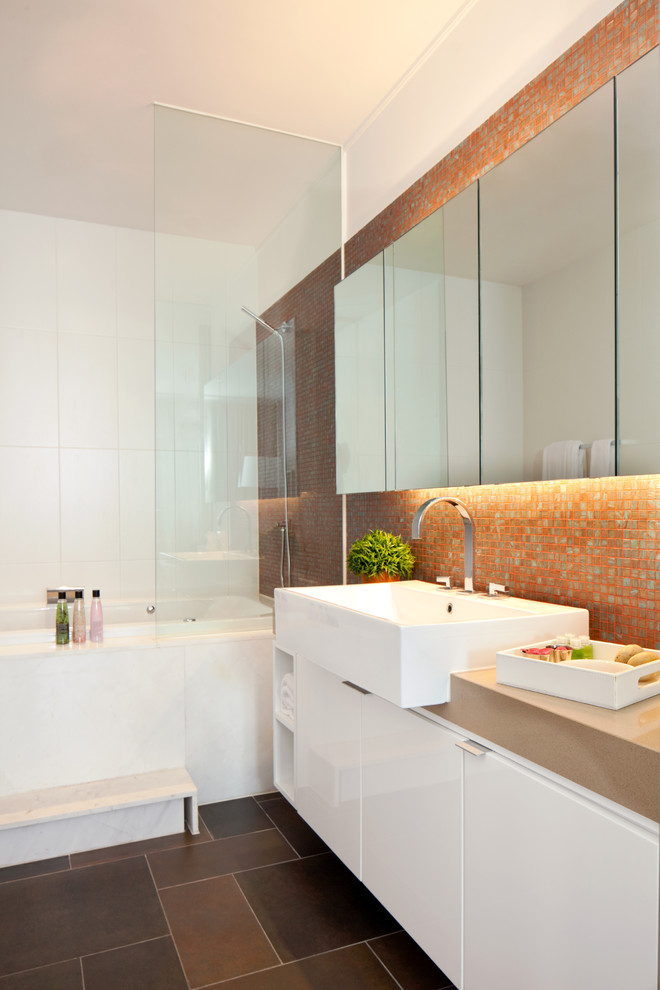This is an example of a mid-sized transitional master bathroom in Malaga with flat-panel cabinets, white cabinets, a freestanding tub, an alcove shower, a wall-mount toilet, orange tile, ceramic tile, orange walls, porcelain floors, a vessel sink, engineered quartz benchtops, brown floor, an open shower and orange benchtops.