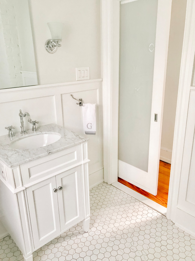 Idéer för mellanstora vintage grått badrum för barn, med luckor med infälld panel, vita skåp, ett badkar med tassar, en toalettstol med separat cisternkåpa, vita väggar, marmorgolv, ett undermonterad handfat, marmorbänkskiva och vitt golv