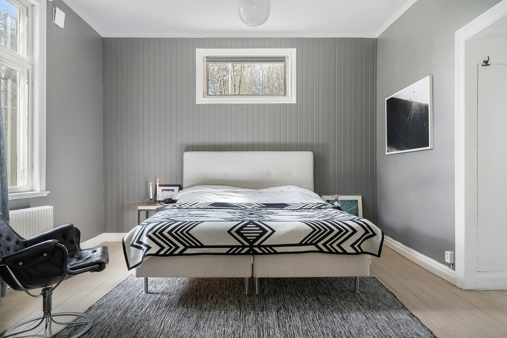 Mid-sized scandinavian guest bedroom in Copenhagen with grey walls, light hardwood floors, no fireplace and beige floor.