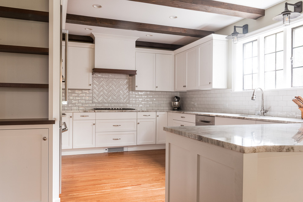 Enclosed kitchen - mid-sized transitional u-shaped medium tone wood floor enclosed kitchen idea with an undermount sink, shaker cabinets, white cabinets, quartzite countertops, white backsplash, subway tile backsplash, stainless steel appliances and a peninsula