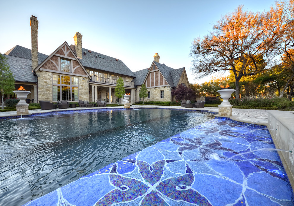 This is an example of a large traditional custom-shaped pool in Dallas with a water feature.