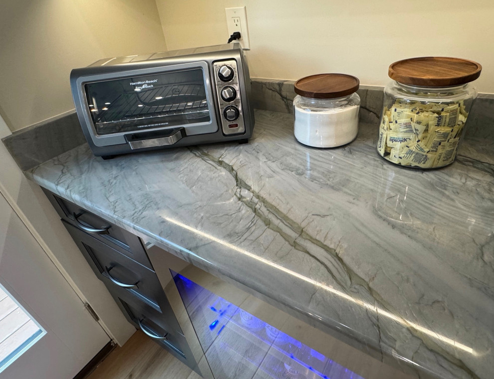 Eat-in kitchen - mid-sized transitional u-shaped laminate floor and brown floor eat-in kitchen idea in Boston with an undermount sink, shaker cabinets, brown cabinets, quartz countertops, black appliances, an island and multicolored countertops