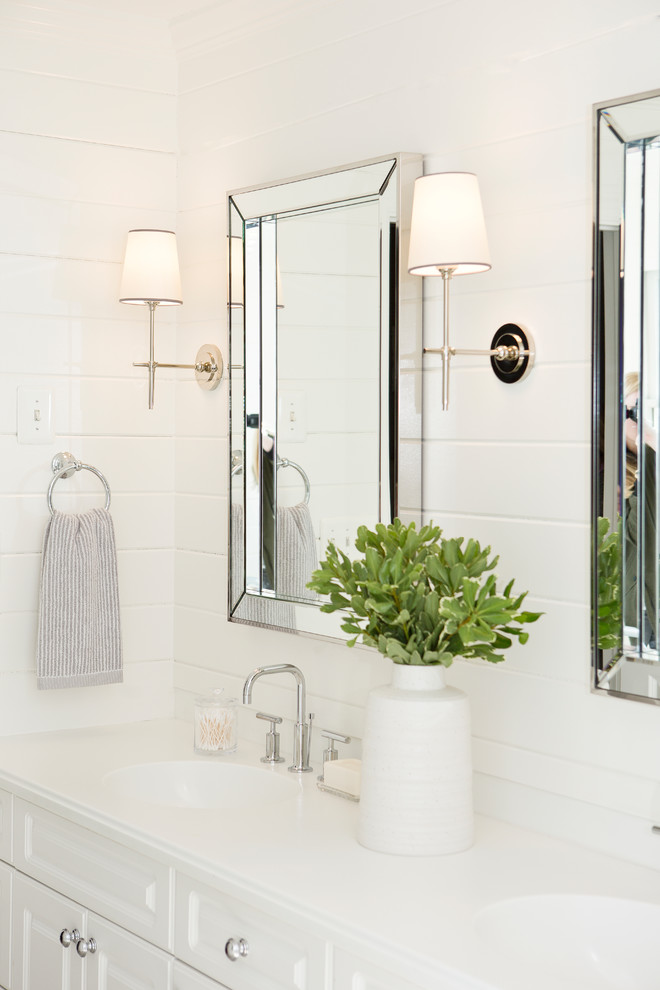 Photo of a small beach style master bathroom in New York with raised-panel cabinets, white cabinets, a drop-in tub, a shower/bathtub combo, a one-piece toilet, white tile, marble, white walls, cement tiles, an undermount sink, marble benchtops, grey floor and a hinged shower door.
