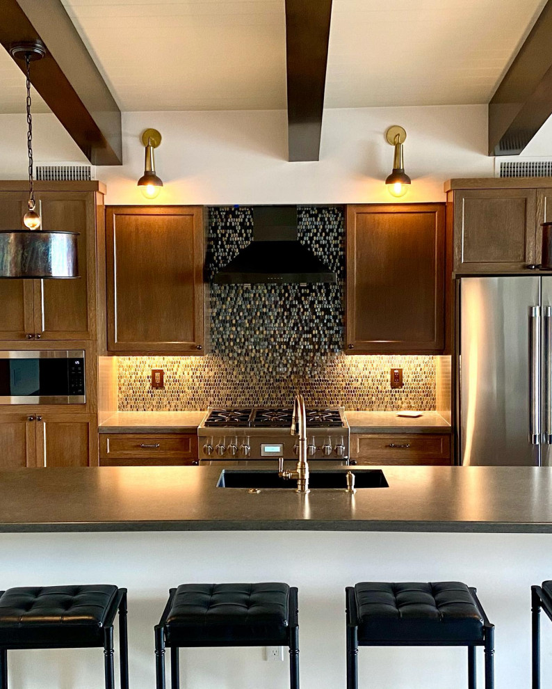 Example of a mid-sized eclectic galley vinyl floor, brown floor and exposed beam open concept kitchen design in Orange County with an undermount sink, shaker cabinets, medium tone wood cabinets, quartz countertops, multicolored backsplash, metal backsplash, stainless steel appliances, an island and brown countertops