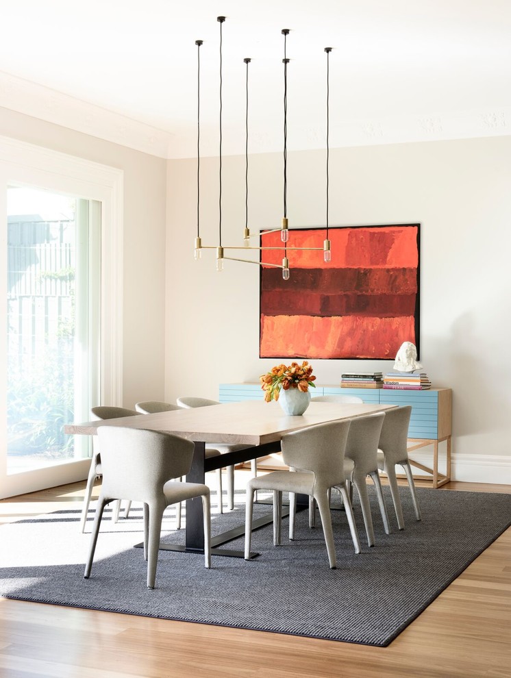 Photo of a mid-sized contemporary dining room in Sydney with grey walls and light hardwood floors.