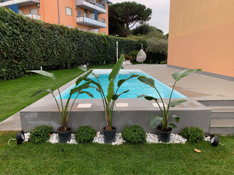 Idee per una piscina fuori terra minimal rettangolare di medie dimensioni e dietro casa con pavimentazioni in pietra naturale