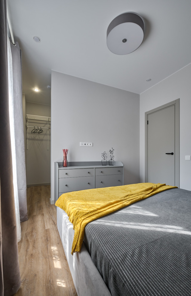 Exemple d'une petite chambre parentale grise et jaune tendance avec un mur gris, un sol en vinyl et un sol marron.