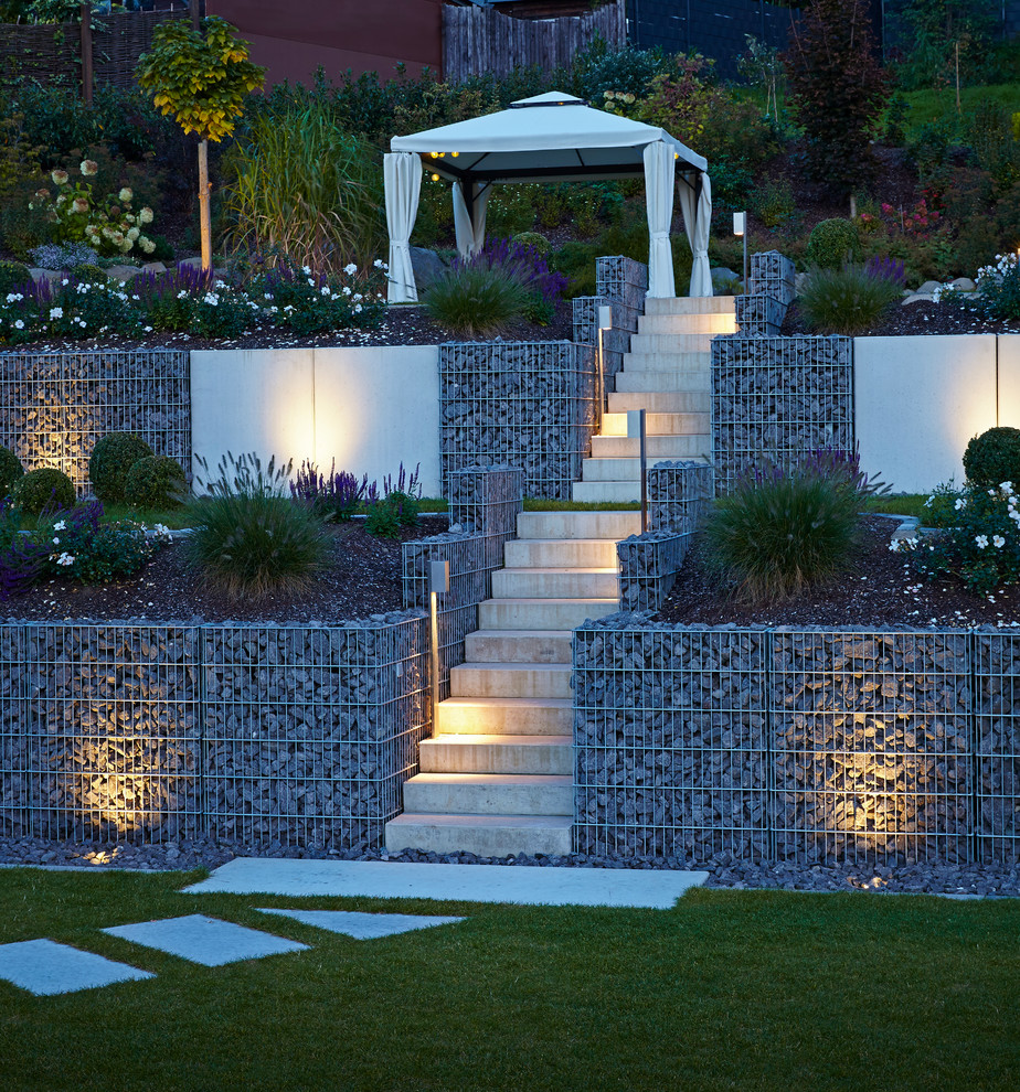 This is an example of a large contemporary side yard partial sun garden for summer in Other with a garden path and natural stone pavers.
