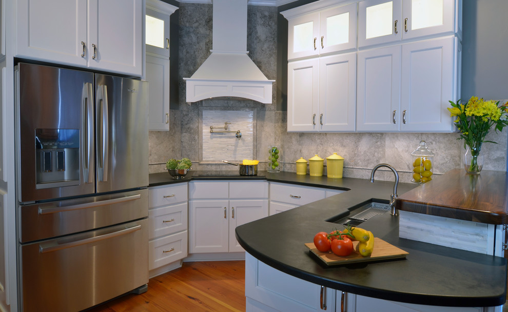 Photo of a transitional u-shaped eat-in kitchen in DC Metro with an undermount sink, shaker cabinets, white cabinets, granite benchtops, grey splashback, stone tile splashback and stainless steel appliances.