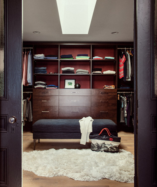 Immagine di uno spazio per vestirsi unisex minimalista con ante lisce, ante in legno bruno e pavimento in legno massello medio