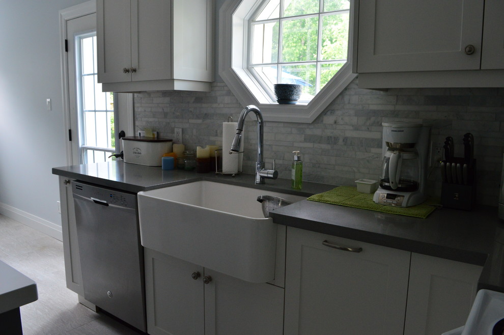 Mid-sized transitional l-shaped vinyl floor and gray floor eat-in kitchen photo in Toronto with a farmhouse sink, shaker cabinets, white cabinets, quartz countertops, gray backsplash, marble backsplash, stainless steel appliances and an island
