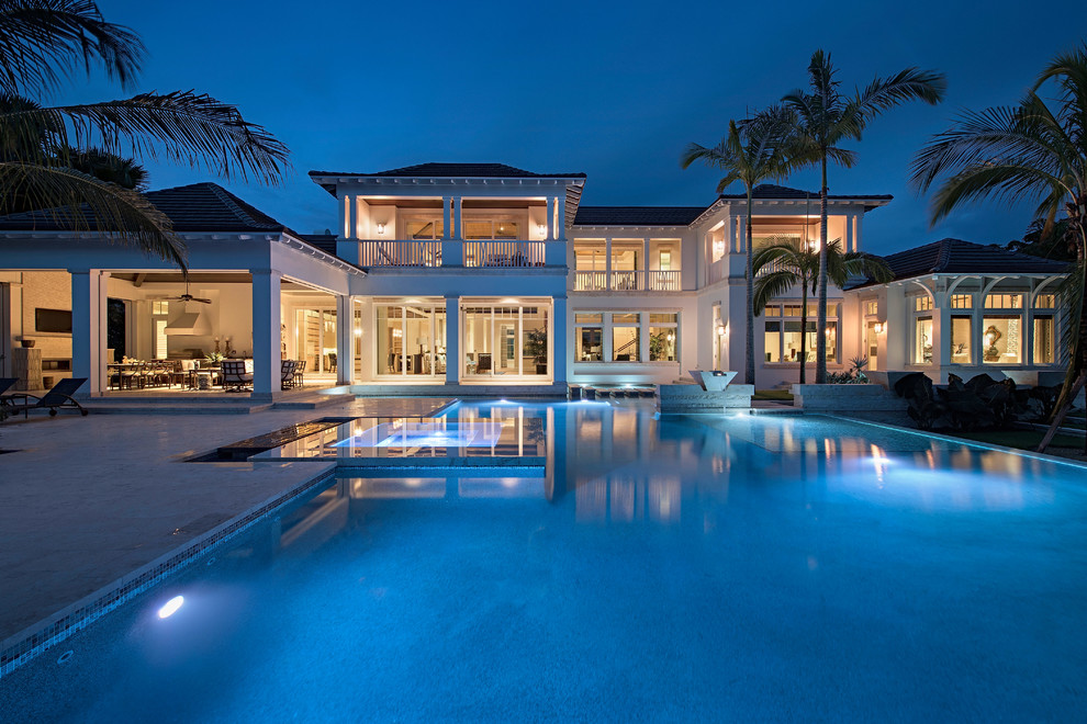 Photo of a tropical pool in Miami with natural stone pavers.
