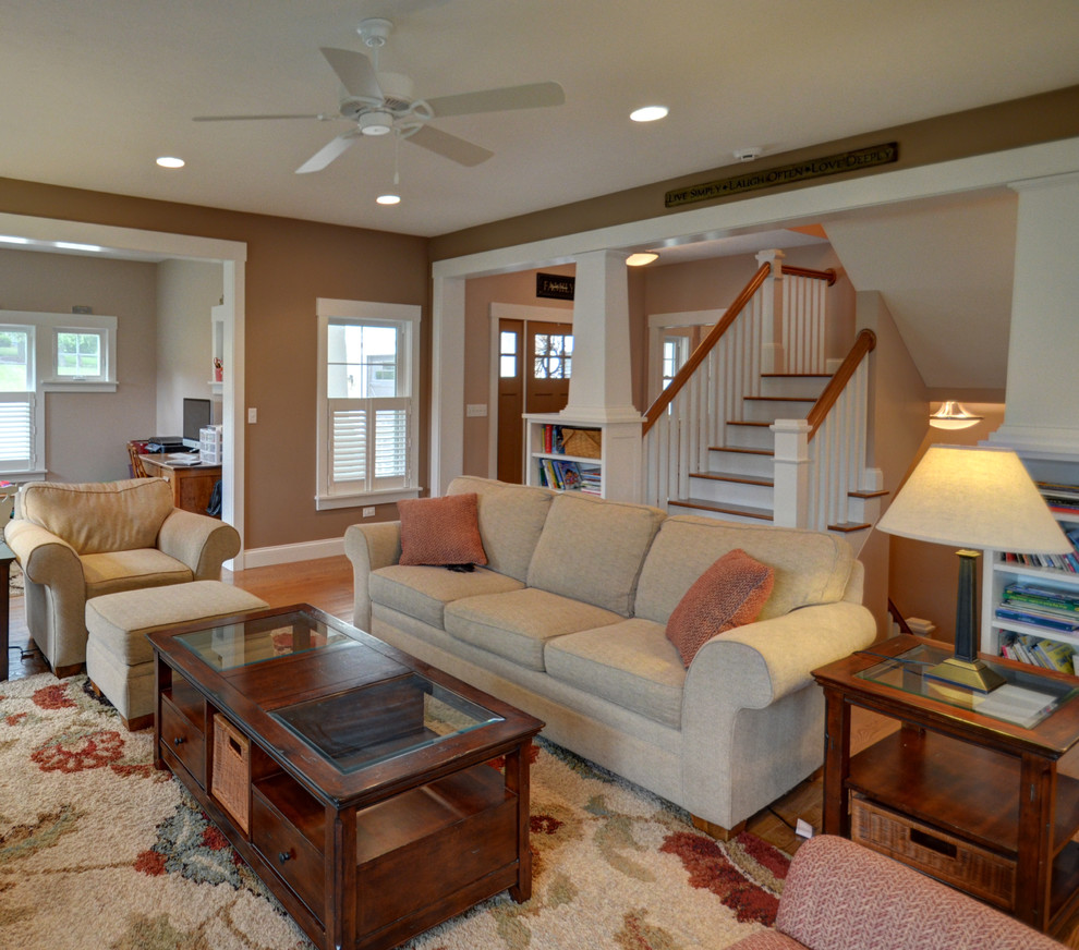Mid-sized arts and crafts open concept family room in Columbus with brown walls, medium hardwood floors, no fireplace and a built-in media wall.
