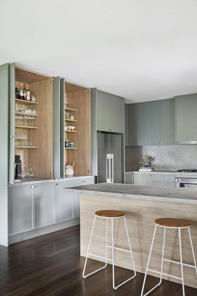 Mid-sized scandinavian galley open plan kitchen in Other with an undermount sink, shaker cabinets, green cabinets, solid surface benchtops, grey splashback, stone slab splashback, stainless steel appliances, dark hardwood floors, with island, black floor, grey benchtop and recessed.