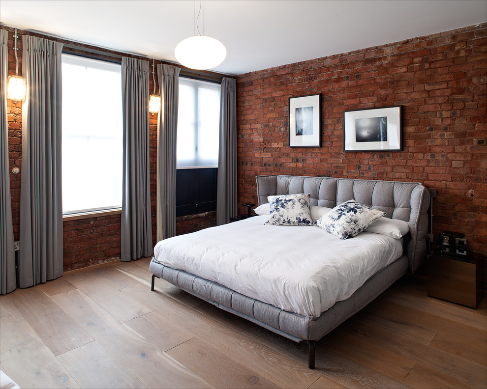 Mid-sized contemporary master bedroom in London with red walls and medium hardwood floors.