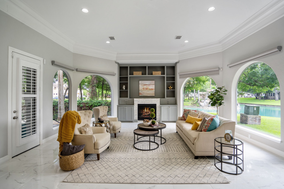Design ideas for an expansive traditional open plan living room in Houston with white walls, a standard fireplace, a wooden fireplace surround, white floors and a drop ceiling.