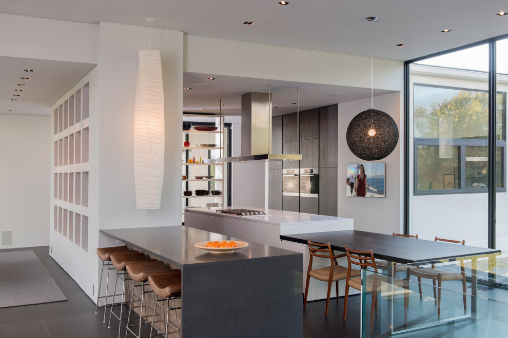 Пример оригинального дизайна: огромная кухня-столовая в современном стиле с белыми стенами, полом из керамогранита, серым полом и многоуровневым потолком