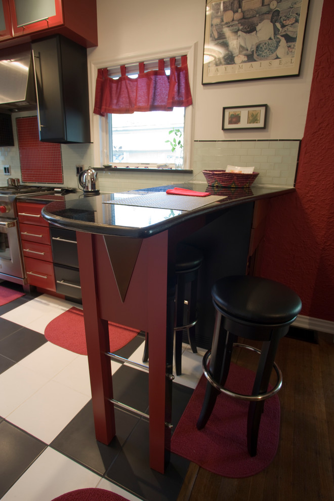Inspiration for a small modern l-shaped eat-in kitchen in Indianapolis with an undermount sink, flat-panel cabinets, red cabinets, granite benchtops, multi-coloured splashback, glass tile splashback, stainless steel appliances, ceramic floors and a peninsula.