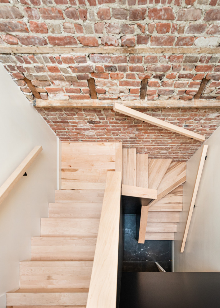 Design ideas for a mid-sized modern u-shaped staircase in Toronto with wood railing and brick walls.