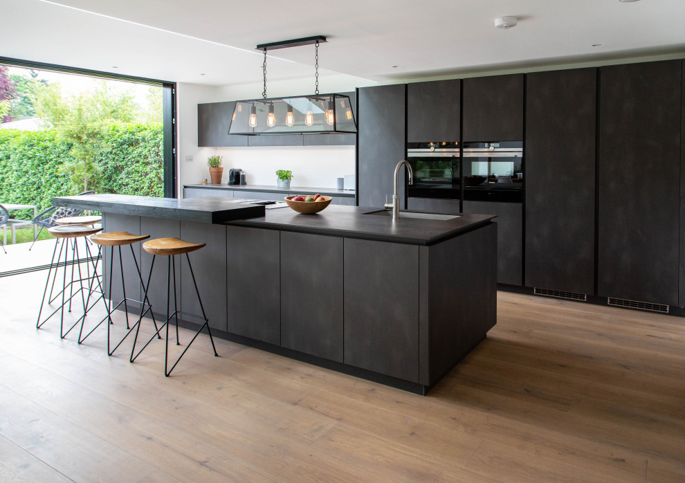 This is an example of an expansive contemporary open plan kitchen in London with with island.
