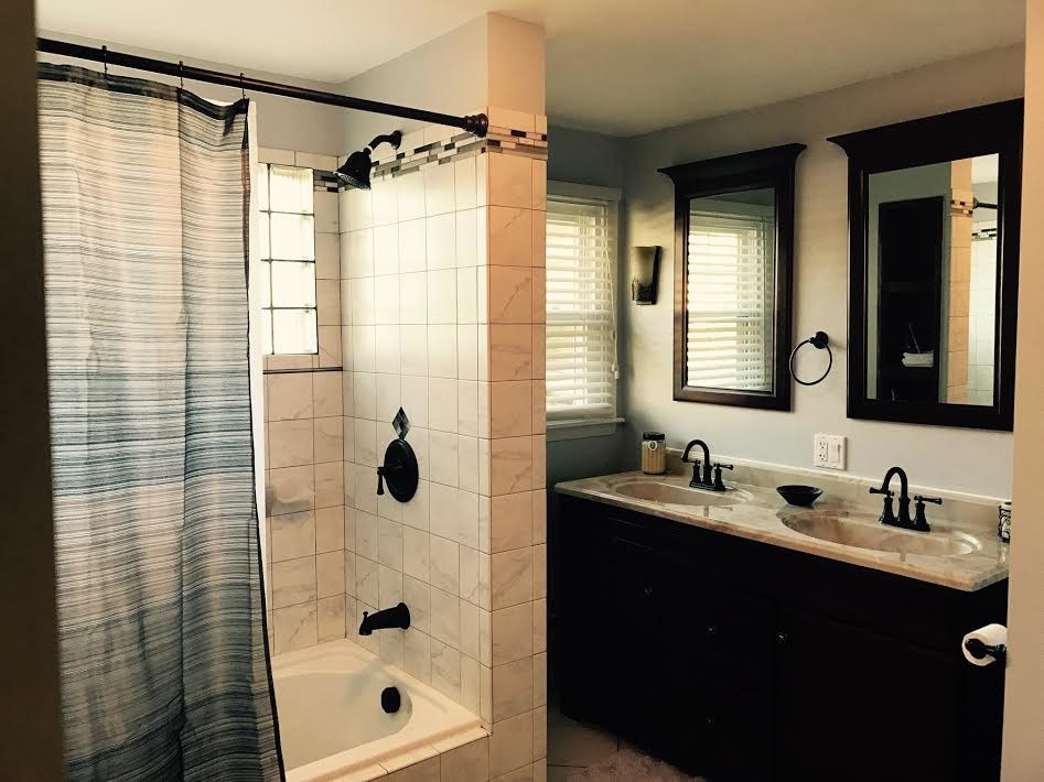 Mid-sized transitional gray tile, white tile and ceramic tile ceramic tile and beige floor tub/shower combo photo in Phoenix with black cabinets, beige walls, granite countertops and an integrated sink