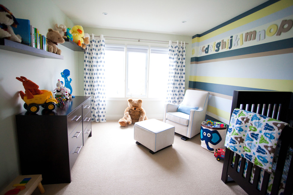 Contemporary nursery in Toronto with carpet and multi-coloured walls for boys.