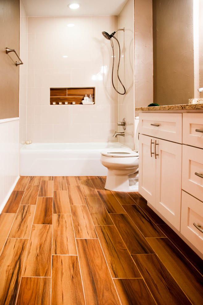 Design ideas for a mid-sized transitional master bathroom in Dallas with granite benchtops, a two-piece toilet, white tile, ceramic tile, brown walls, ceramic floors, shaker cabinets, white cabinets, an alcove tub, a shower/bathtub combo, an undermount sink, brown floor and a shower curtain.