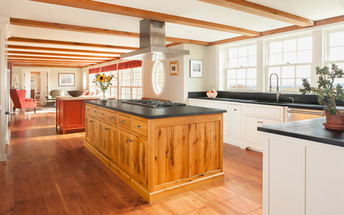 Photo of an expansive country kitchen in Boston with an undermount sink, beaded inset cabinets, white cabinets, soapstone benchtops, black splashback, stone slab splashback, stainless steel appliances, medium hardwood floors and multiple islands.