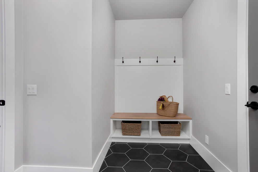 Inspiration for a mid-sized country mudroom in Seattle with grey walls, ceramic floors, a gray front door and black floor.