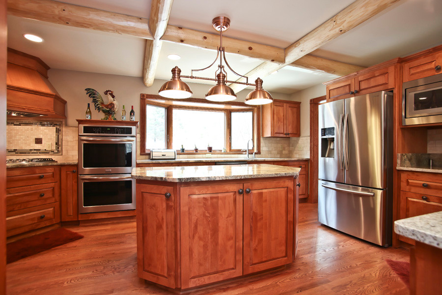 Eat-in kitchen - large rustic u-shaped medium tone wood floor eat-in kitchen idea in Milwaukee with a single-bowl sink, shaker cabinets, medium tone wood cabinets, granite countertops, beige backsplash, ceramic backsplash, stainless steel appliances and an island