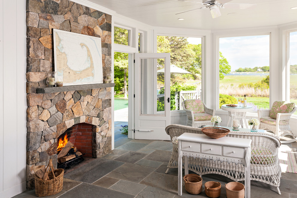 This is an example of a traditional sunroom in Boston with a standard fireplace, a brick fireplace surround and a standard ceiling.