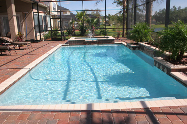 Pool fountain - large backyard brick and custom-shaped pool fountain idea in Jacksonville