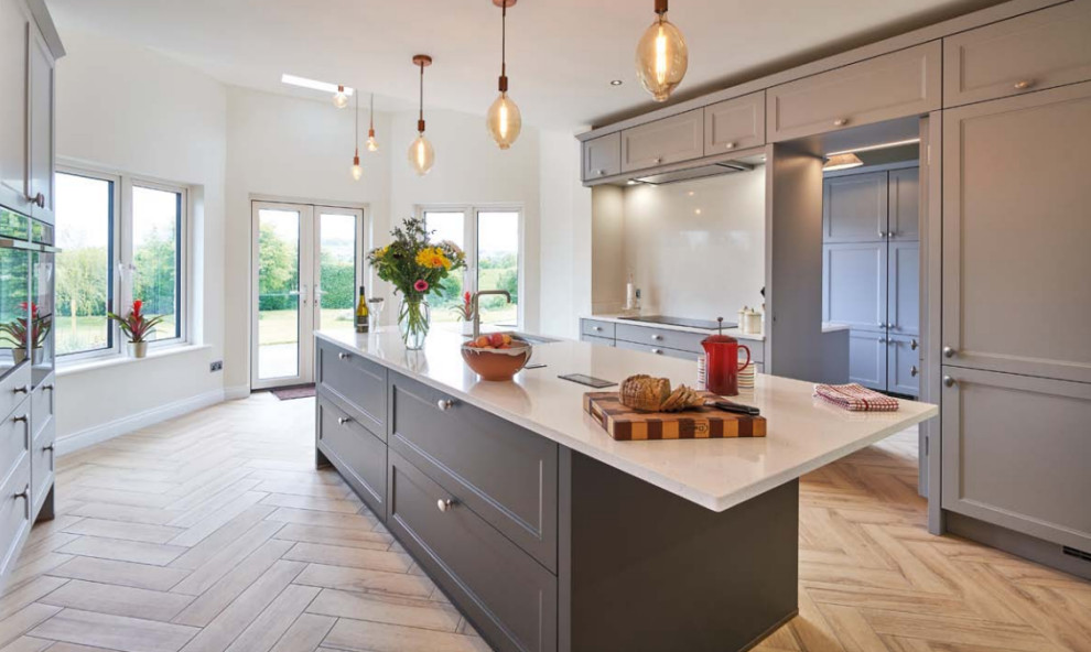 This is an example of an eclectic kitchen in Other with a drop-in sink, quartzite benchtops, white splashback, slate splashback, stainless steel appliances, ceramic floors, brown floor, white benchtop and recessed.