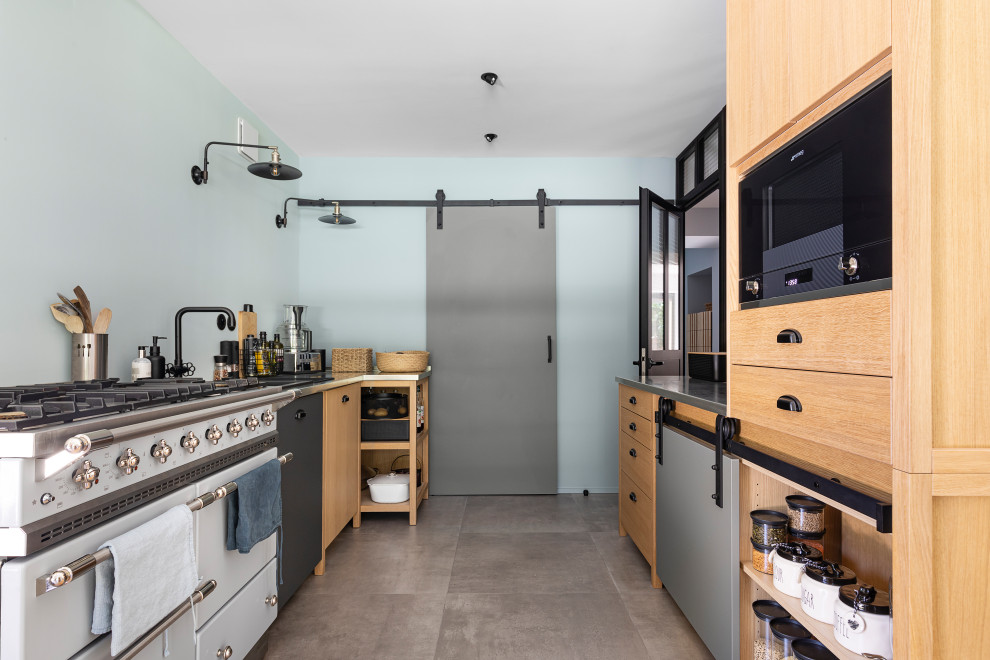 Zweizeilige Moderne Küche mit flächenbündigen Schrankfronten, hellbraunen Holzschränken, weißen Elektrogeräten, grauem Boden und grauer Arbeitsplatte in Lyon