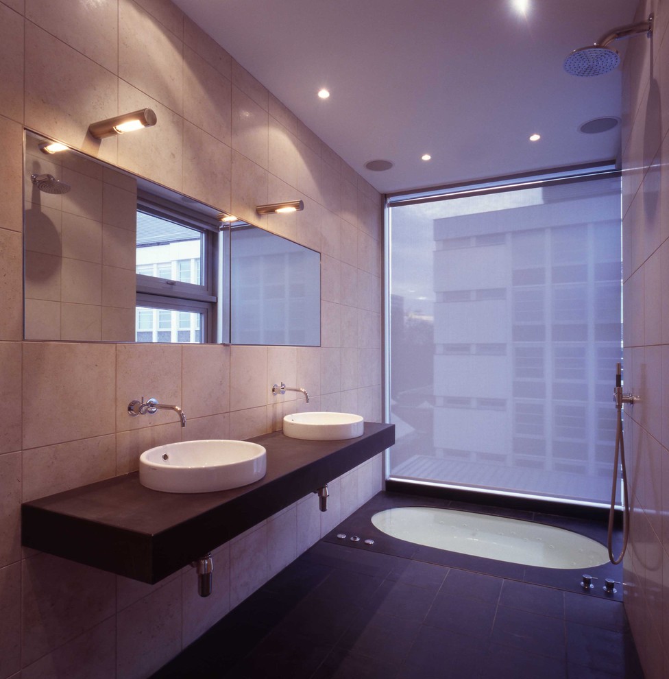 Photo of a contemporary bathroom in London with a vessel sink, an undermount tub, beige tile and a curbless shower.