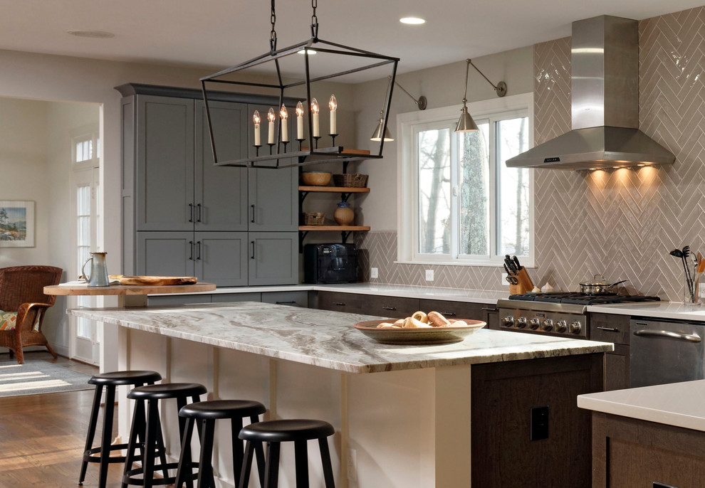 This is an example of a large transitional u-shaped eat-in kitchen in DC Metro with a farmhouse sink, shaker cabinets, medium wood cabinets, quartz benchtops, beige splashback, subway tile splashback, stainless steel appliances, light hardwood floors and with island.