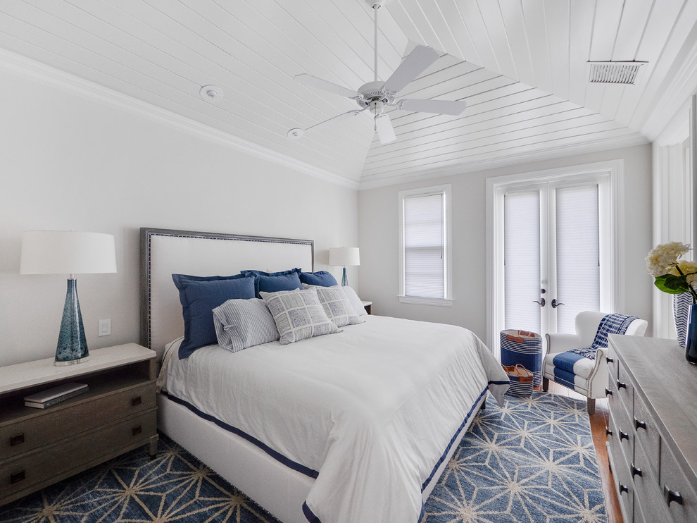 Design ideas for a beach style guest bedroom in Miami with grey walls, medium hardwood floors and no fireplace.