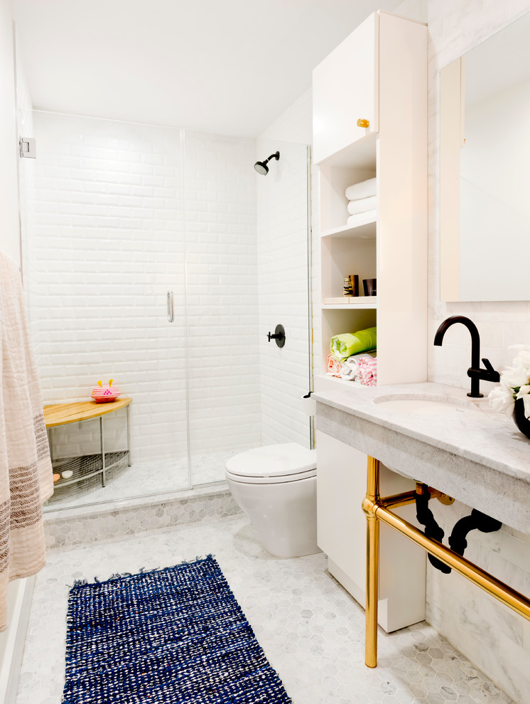 Inspiration for a mid-sized transitional 3/4 bathroom in New York with open cabinets, white cabinets, an alcove shower, white tile, subway tile, white walls, mosaic tile floors, an undermount sink, a one-piece toilet, marble benchtops, a hinged shower door and grey benchtops.